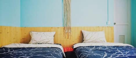 Habitación con dos camas, cabecero de madera y un adorno en la pared.