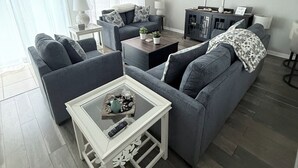 A living room with a grey sofa, a coffee table, a TV, and a cabinet.