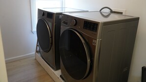 A laundry room with two stacked washing machines and a dryer.