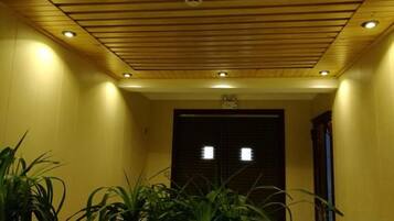 A hallway with a wooden ceiling and recessed lighting.