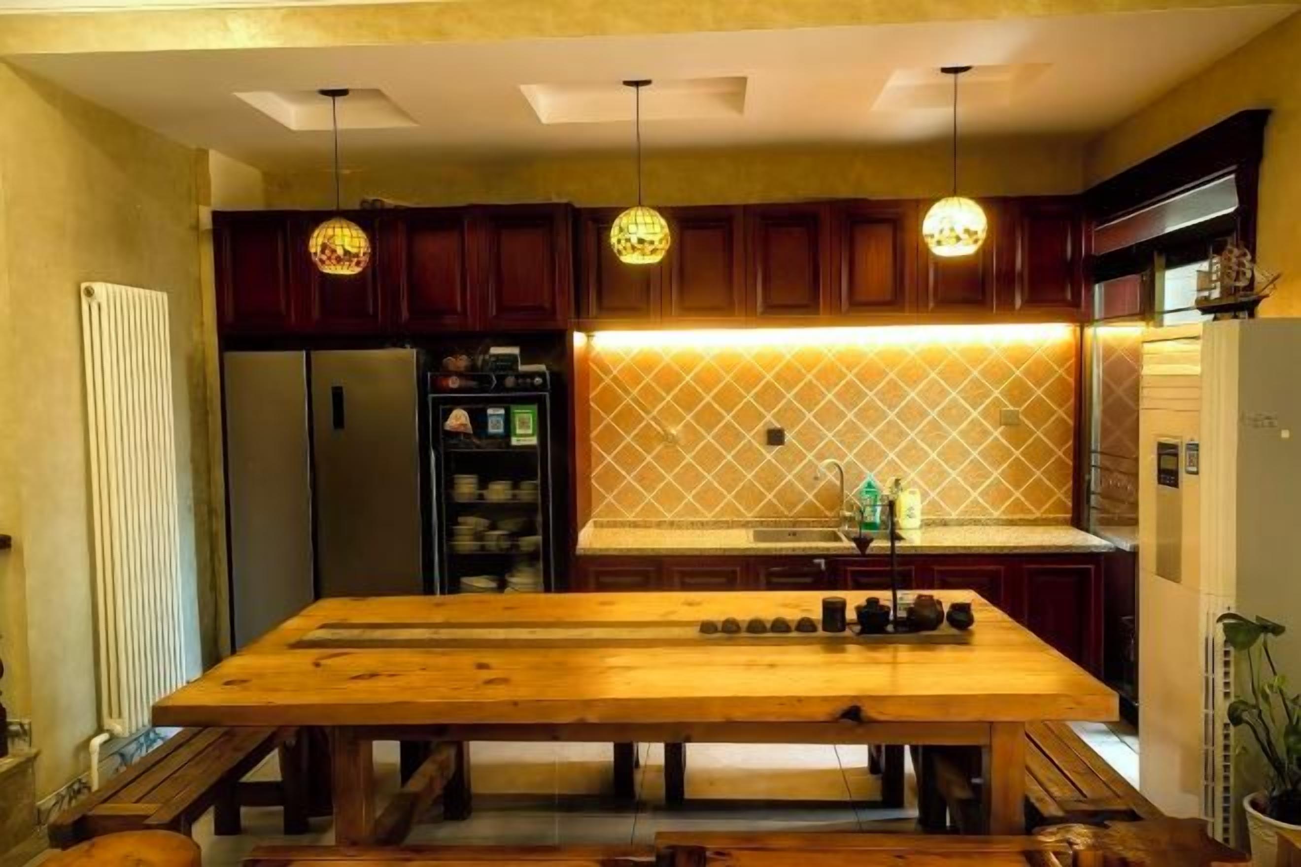 A kitchen with a wooden table, pendant lights, and a tiled backsplash.