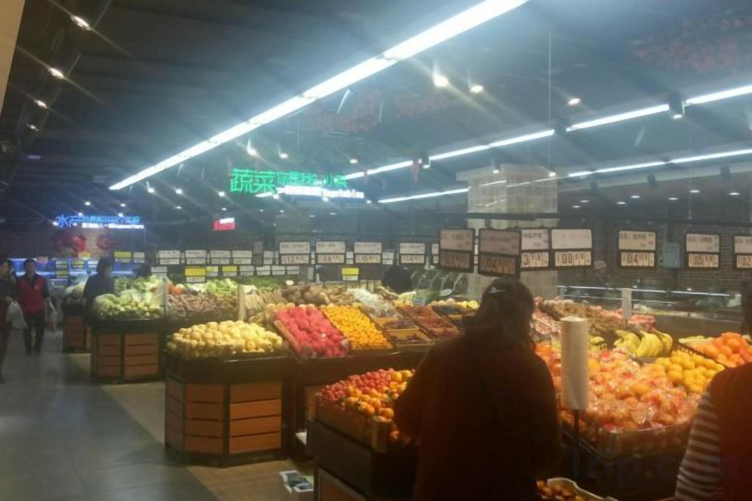 A grocery store interior with produce sections and price tags.