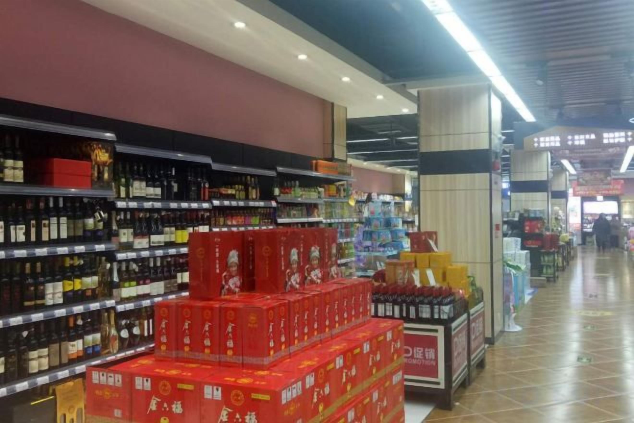 Un pasillo de supermercado con estantes llenos de diversos productos, entre ellos, artículos en caja y botellas.