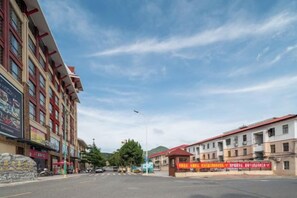 A street view with buildings, a clear sky, and a crosswalk. - Jinhengsheng Holiday Hotel (Yunxiao)