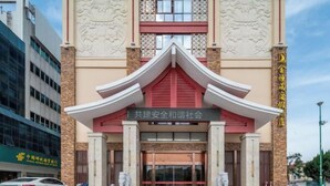 A building with a traditional architectural style, featuring a prominent entrance with a red roof and decorative elements.