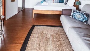 Un dormitorio amplio con una cama grande, techo de madera y vista a un balcón.