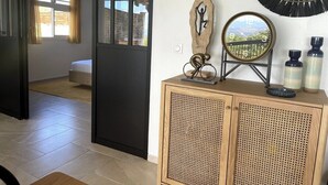 Ein Hotelzimmer mit einem Bett, einem Nachttisch mit Dekoration, einer Wanduhr und einem Spiegel.