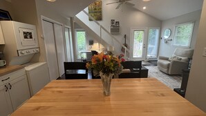 Eine Küche mit einem Holztisch, einer Blumenvase und einem Deckenventilator.