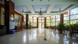 A spacious lobby with a high ceiling, large windows, and a chandelier. - Shuangyuanhui Resort (Beijing)
