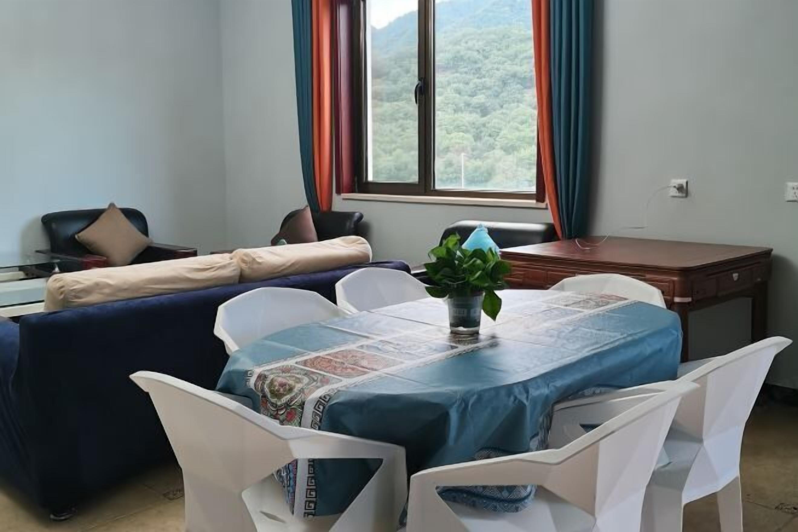 A room with a bed, a desk, a chair, and a table.