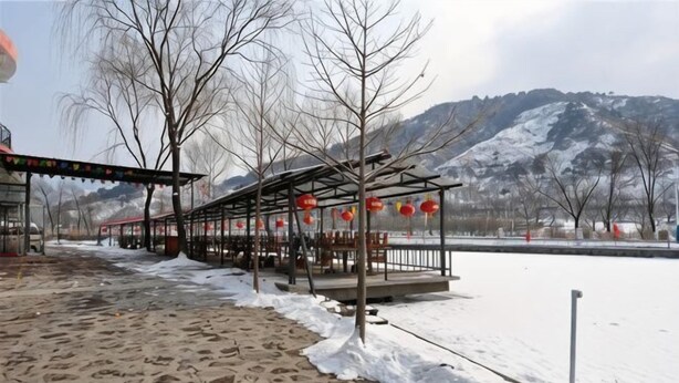 A covered pavilion with a snow-covered ground, a river, and mountains in the background. - Shuangyuanhui Resort (Beijing)