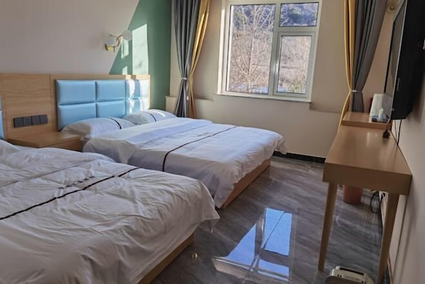 A hotel room with two beds, a wooden headboard, a small table, and a window with curtains. - Shuangyuanhui Resort (Beijing)