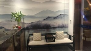 Uma área de estar moderna com sofás, uma mesinha e uma planta decorativa.