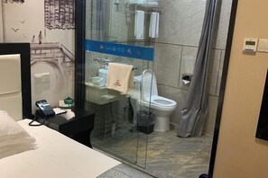 A hotel bathroom with a glass shower enclosure, a toilet, and a sink. - Shanyushui Post Inn (Nantong)