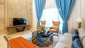 Un salon moderne comprenant un canapé, des fauteuils, une table basse et un téléviseur.