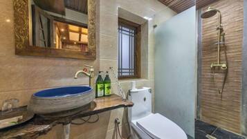 A bathroom with a marble sink, a toilet, and a shower.