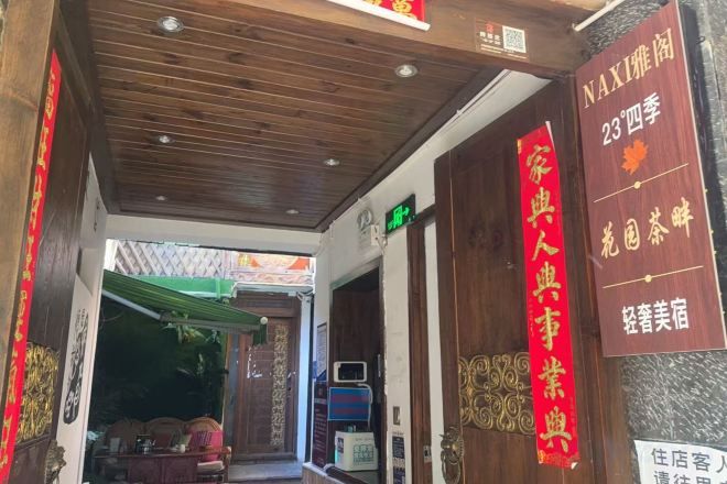 A hotel entrance with a wooden ceiling and a red sign indicating a traditional Chinese theme.