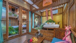 A wooden interior with a bed, a dining table with fruit, and a plush toy. - NAXI yage hotel (Lijiang)