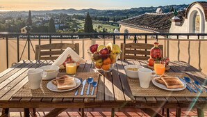 A breakfast setup on a balcony overlooking a scenic landscape with buildings and hills. - Nice apartment in Mijas with house sea view (Mijas)