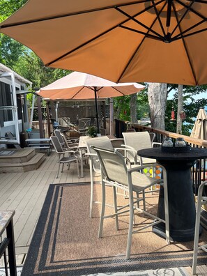 Une terrasse dotée de mobilier d’extérieur, notamment de chaises et de tables, placée sous de grands parasols.