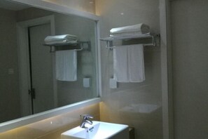 A bathroom with a large mirror, a white sink, and towel racks. - Sincerity Holiday Apartment Hostel (Haikou)