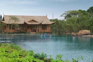 Un edificio tradicional con techo curvo junto a aguas tranquilas.