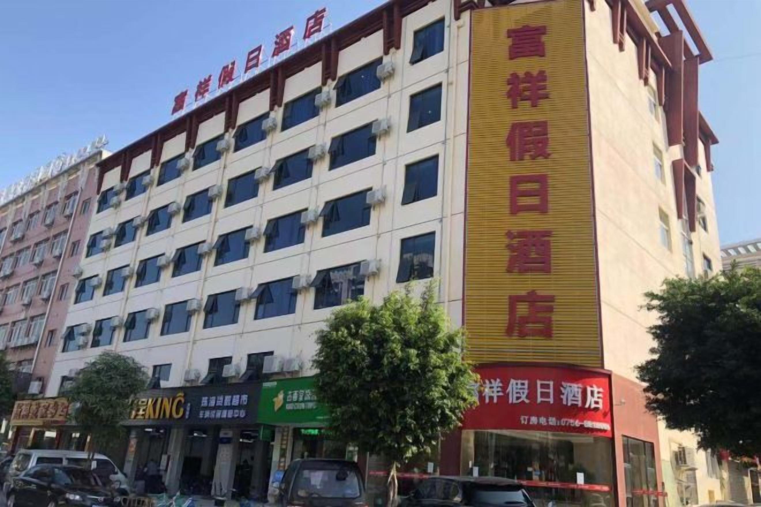 A multi-story hotel with a prominent yellow sign indicating a restaurant on the ground floor.