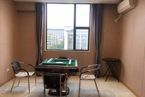 Ein Zimmer mit Pooltisch, zwei Stühlen, einem kleinen Tisch und einem fenster mit Vorhängen.