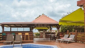 Ein Swimmingpool mit Liegestühlen und einer überdachten Terrasse.