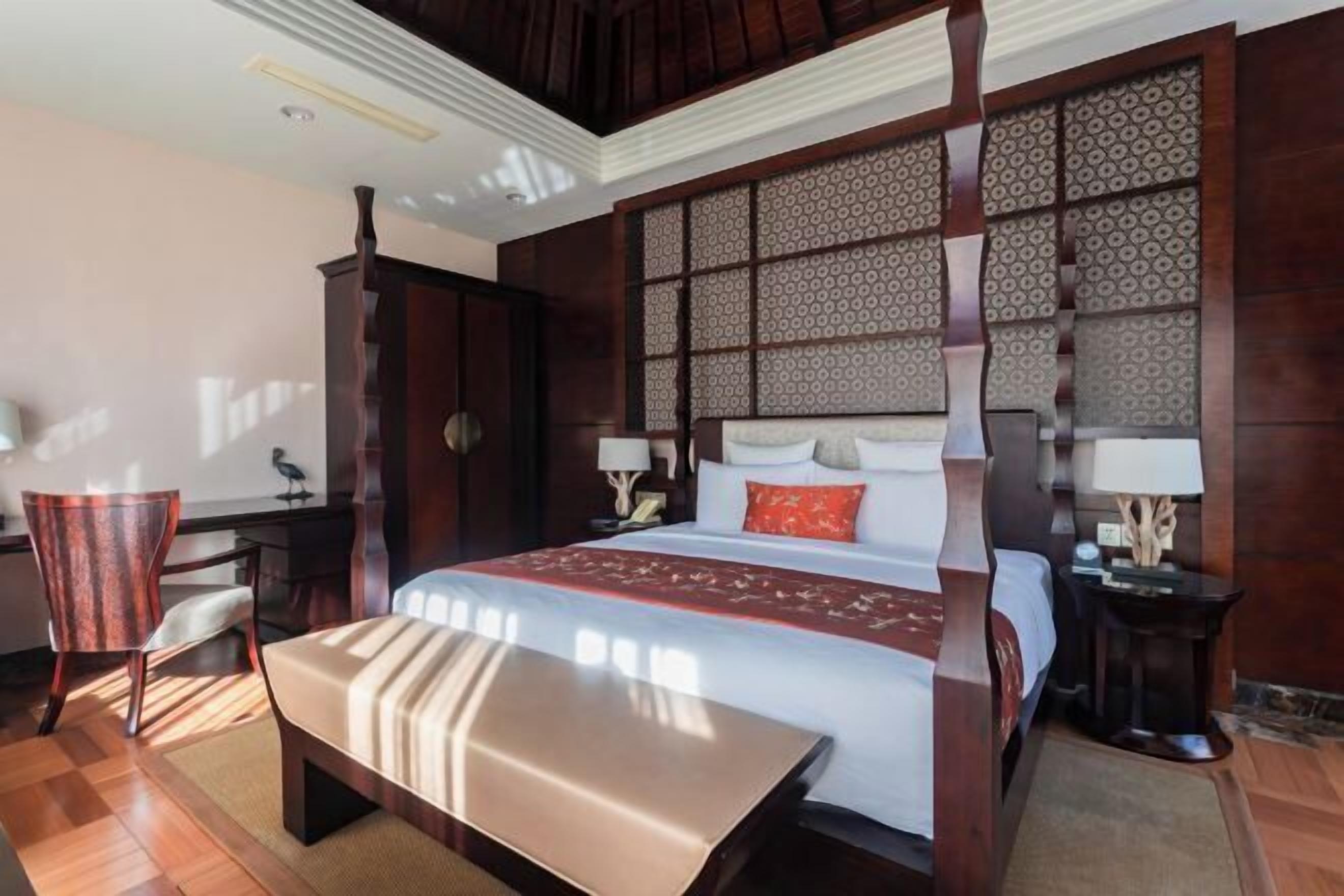 Een hotelkamer met een groot bed, een bureau en een stoel.