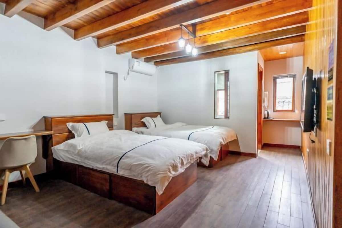 Une chambre avec deux lits, un bureau et une chaise.
