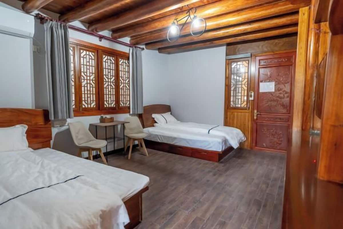 Une chambre d’hôtel avec deux lits, une petite table et une chaise.