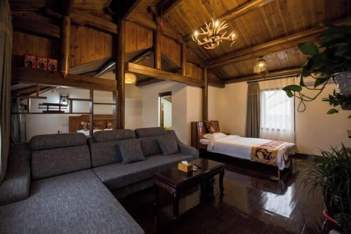 Un intérieur en bois comprenant un canapé, un lit, un lustre et une plante en pot.