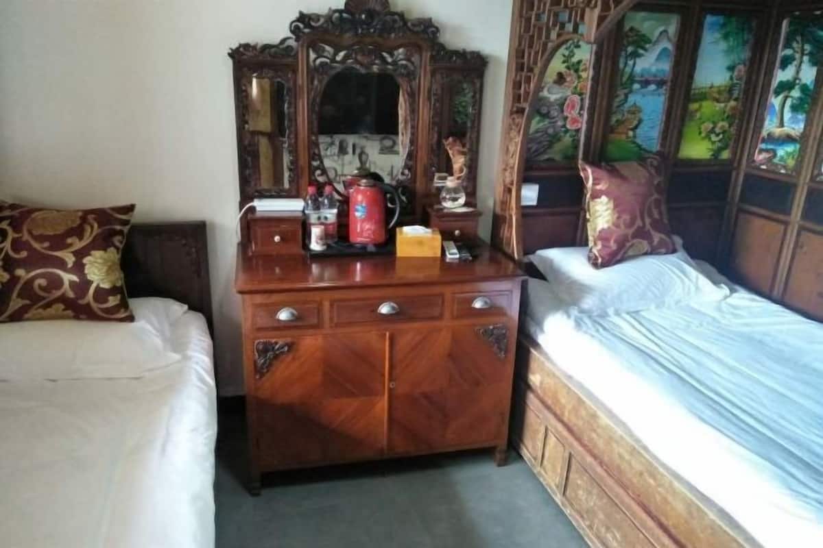 Une pièce comprenant une commode en bois, un lit et un miroir doté d’un cadre décoratif.