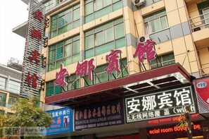 A building with a sign that reads '安娜宾馆' and another sign below it that says 'ecal room 80%.' - Anna Hostel (Yiwu)