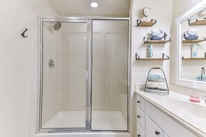 Bañera con ducha, toallas, papel higiénico