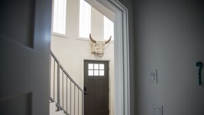 Un escalier menant à une porte surmontée d’une décoration représentant une tête de taureau.