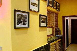 Un pasillo con fotografías enmarcadas en la pared, una barra de mármol y una puerta.