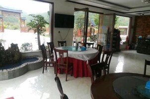 Un comedor con una mesa redonda, sillas y vistas al exterior.
