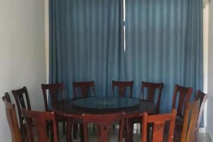 Una mesa redonda de comedor con ocho sillas de madera.
