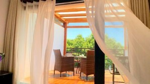 A room with a wooden ceiling, white curtains, wicker chairs, and a view of greenery outside. - Shuishangju Japanese Landscape Inn Suzhou Tongli (Suzhou)