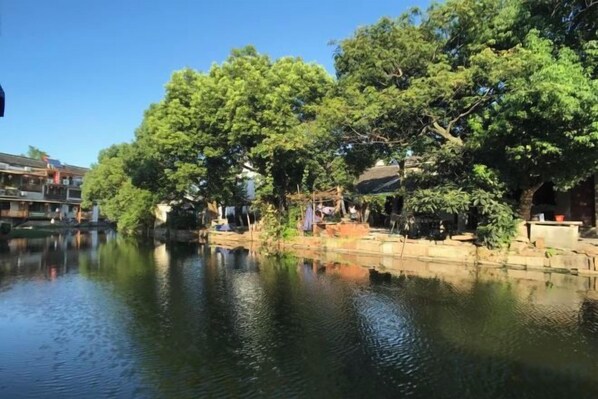 A calm river with trees and buildings along the banks.