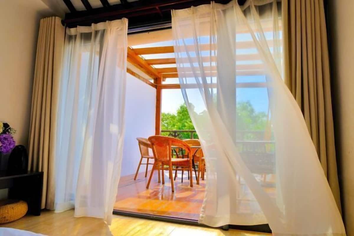 Une pièce dotée d’une porte-fenêtre coulissante donnant sur un patio extérieur avec une table et des chaises.