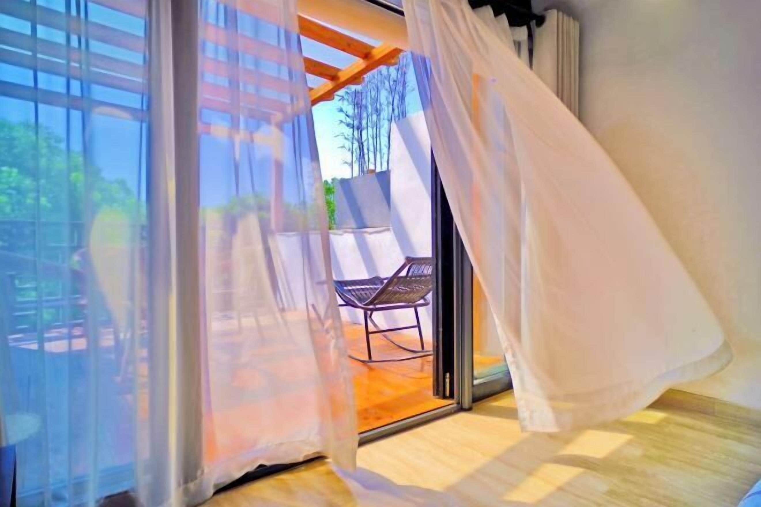 A room with a sliding glass door leading to an outdoor seating area.