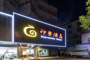 Un hôtel doté d’une enseigne lumineuse bien visible, sur laquelle figurent son nom et son logo.