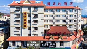 Hotel de varios pisos con techo rojo y un cartel que indica que es un hotel para empresas.