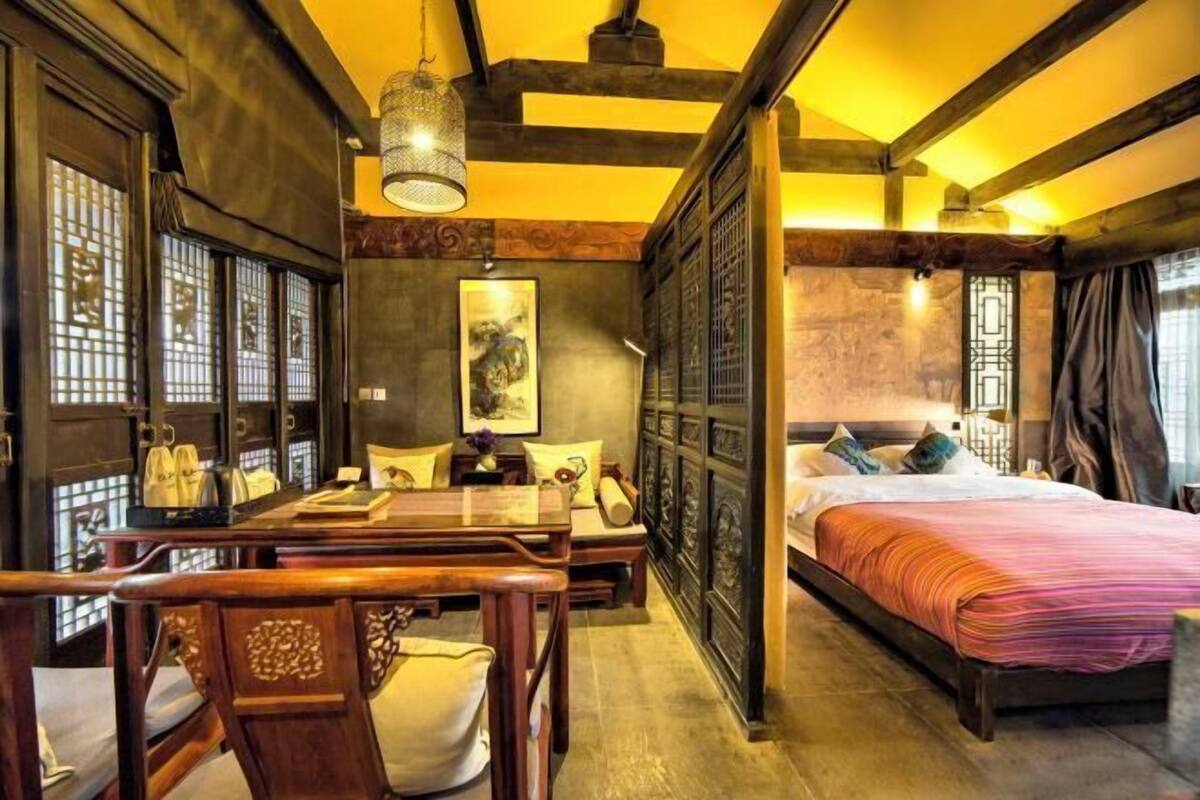 A traditional room with a bed, a desk, and a chair.