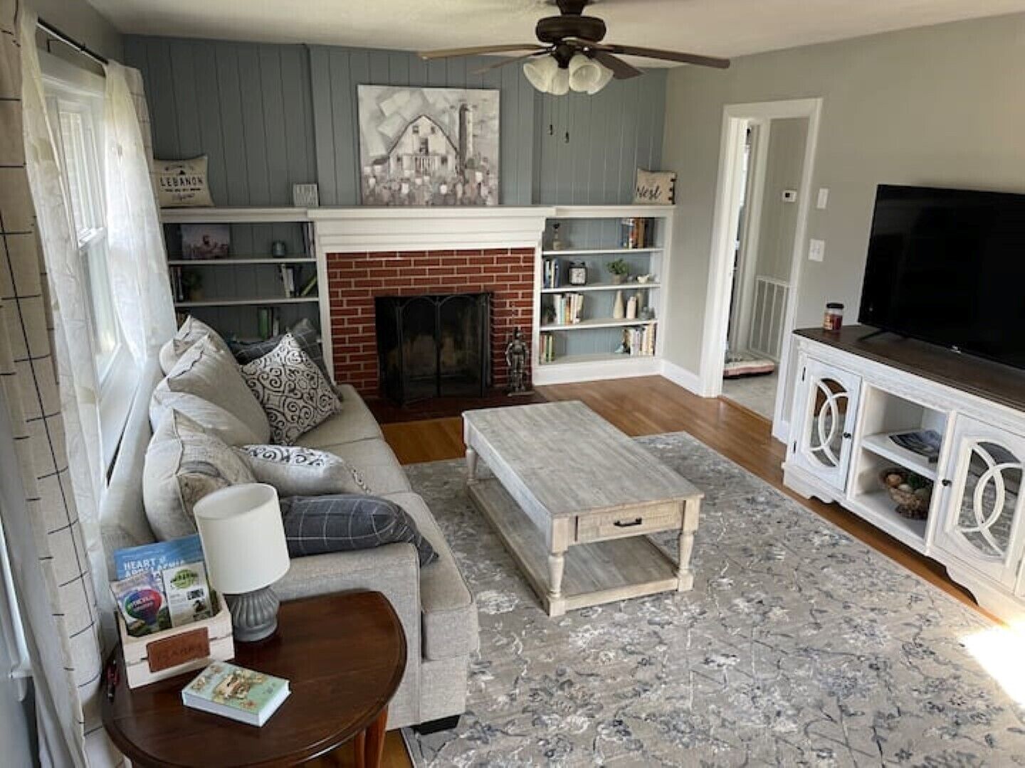 A living room with a fireplace, a sofa, a coffee table, and a TV.