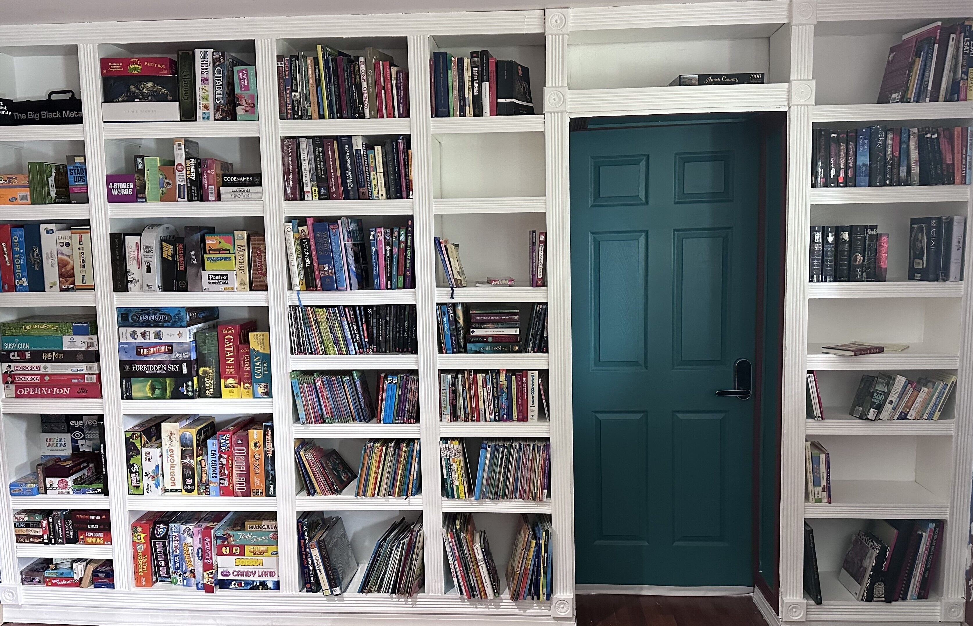 Een kamer met een grote boekenkast vol boeken en dvd's.