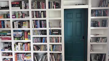 Een kamer met een grote boekenkast vol boeken en dvd's.